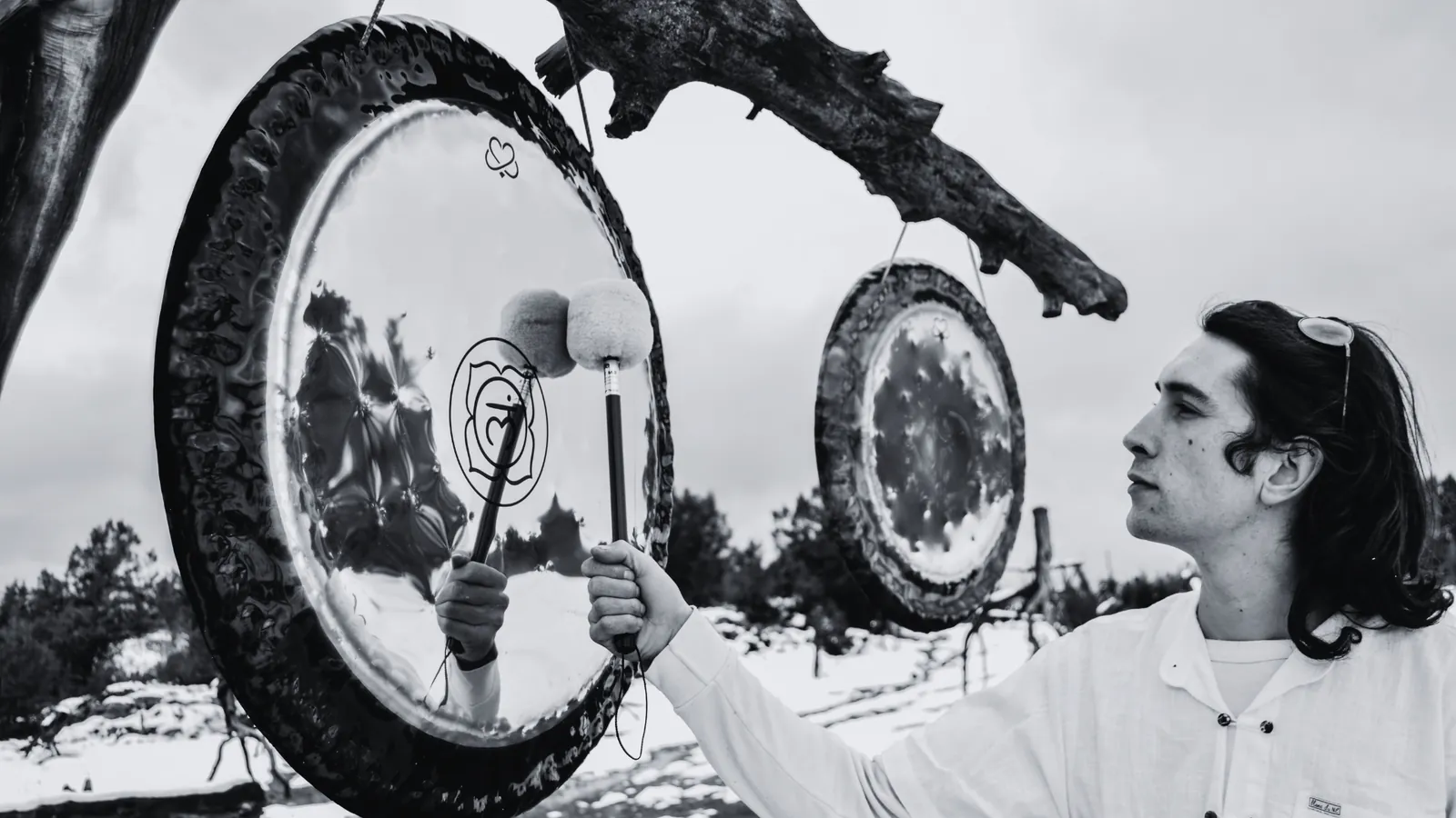 Adrián Lenhardy tocando un Gong artesanal Harmony Gongs en un entorno natural nevado.
