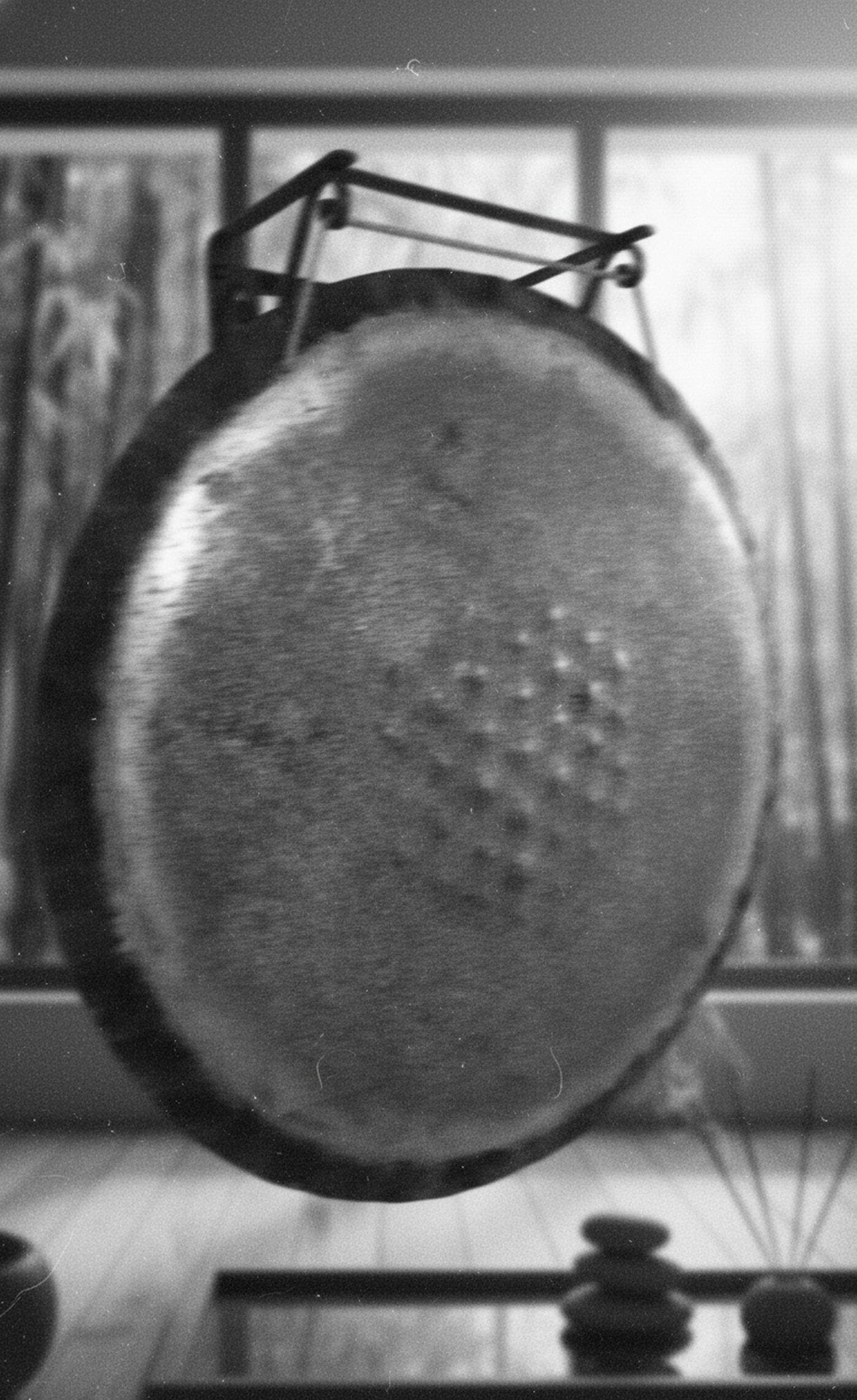 Gong instalado en una sala minimalista de meditación, sobre un soporte artesanal.